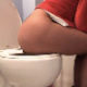 A woman is recorded taking a shit while sitting on a toilet. Several perspectives of the poop action are shown. Dirty toilet paper seen while wiping. Over 7.5 minutes.